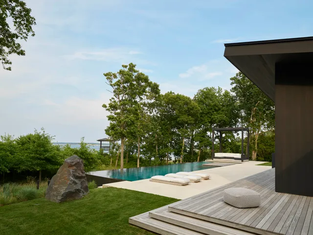 A line of James Perse Chaise Longues stands next to the pool.