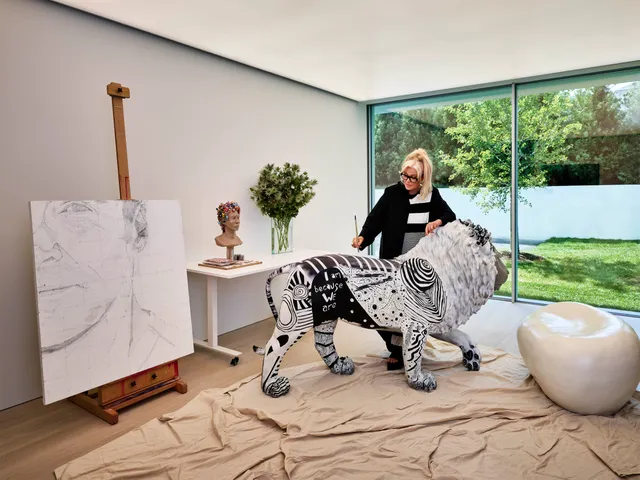 Furness in her art studio with one of her drawings and a lion sculpture for the African Community and Conservation Foundation (ACCF) that she and her son, Oscar, created for The Hamptons Pride 2021.